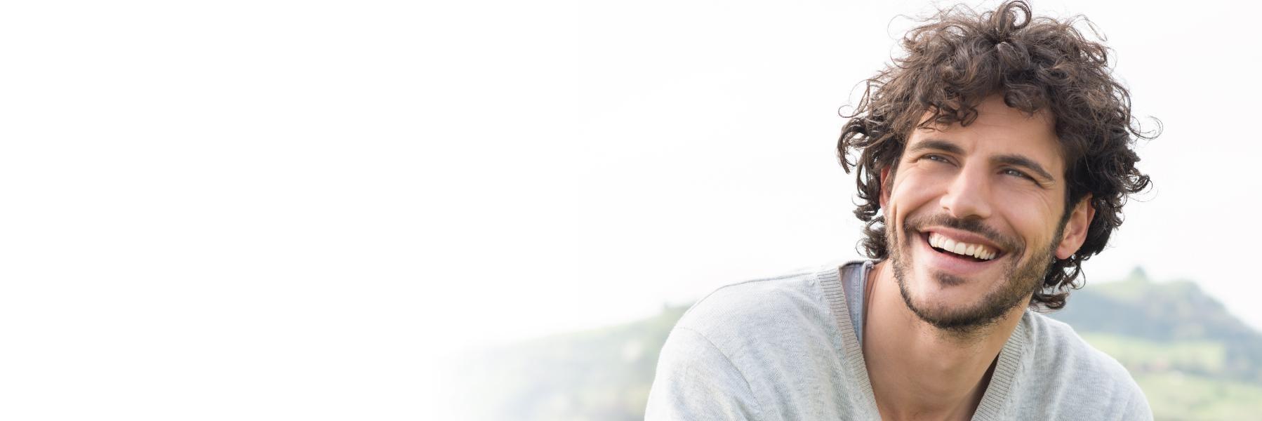 Young man with curly hair smiling l Orthodontics Temple TX